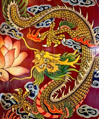Golden Chinese dragon on red silk panel.