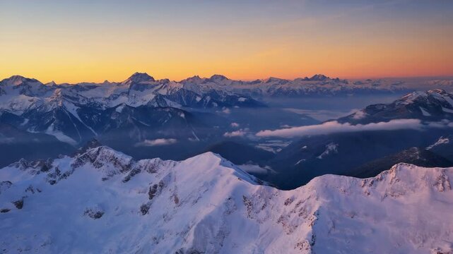 Aerial drone flying above snowy mountain peaks during twilight with blue and violet light reflecting off icy ridges, capturing the quiet beauty of winter in a peaceful high-altitude region