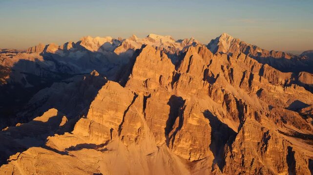 Rocky mountain formations glowing under sunset light with steep ridges and rugged peaks creating a dramatic and scenic landscape of raw geological strength and natural beauty