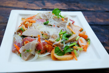Spicy Vermicelli noodle salad with minced pork and Vietnamese pork roll sliced in white dish....