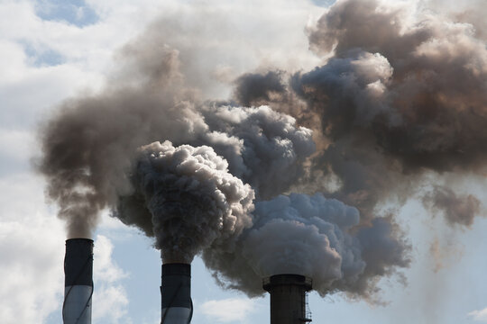 Smoke pouring from smokestacks at a rural sugar refinery