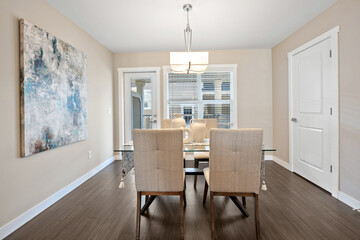 Large painting hangs on the wall above the dining table
