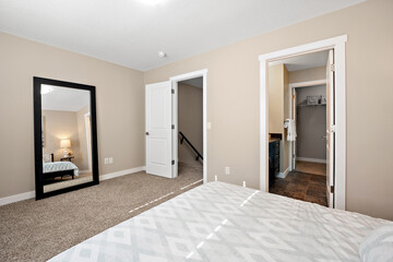 Bedroom with a white bed and a black mirror