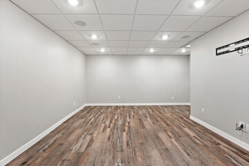 Large, empty room with a wooden floor and white walls