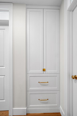 Fototapeta premium White cabinet with two drawers and a gold handle