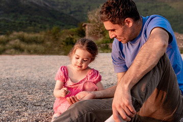Family father and daughter walk on beach, man and girl child on summer vacation