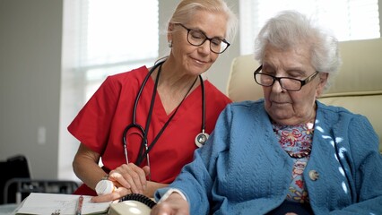A nurse in scrubs interacts warmly with an elderly resident, sharing a light moment while reviewing notes in a comfortable room during the day.