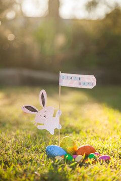 Easter bunny with start here sign at the beginning of an Easter egg hunt