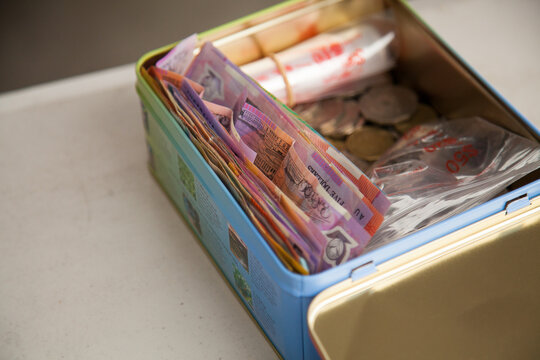 Tin box of money in notes and coins