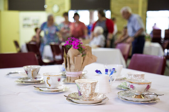 Cup and saucer with food platter on table at a high tea fundraiser event