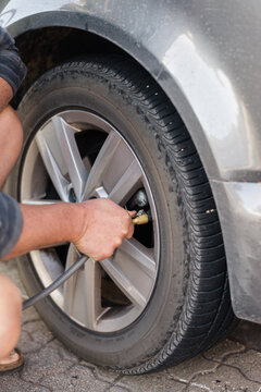 man checking and filling tyres at service station