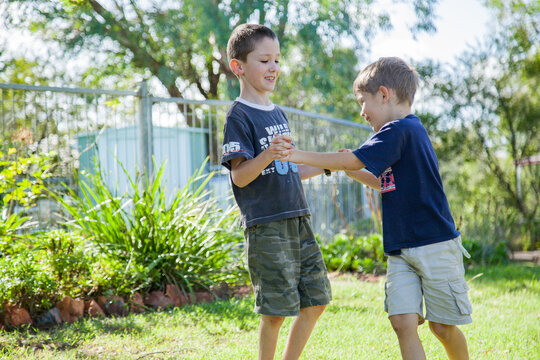Two brothers tackling on the grass outside