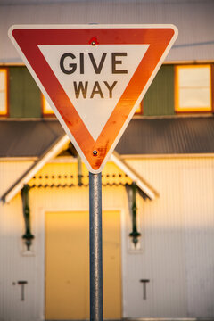 Golden afternoon sun reflecting off Give Way road sign in urban setting