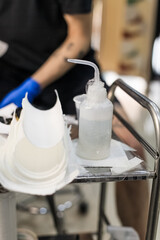 Tattoo artist creating a custom design for a young woman in a cozy Tbilisi studio. Details of the...