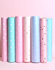 Fototapeta premium Colorful rolls of wrapping paper in pastel shades, featuring polka dots against a light pink background, perfect for gift wrapping and creative projects