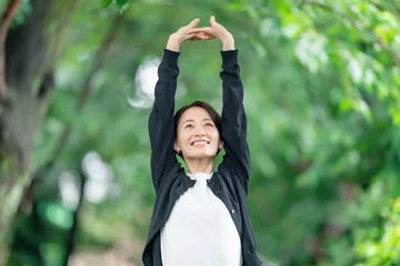 Zelfklevend Fotobehang 新緑　女性　伸び　深呼吸 © naka