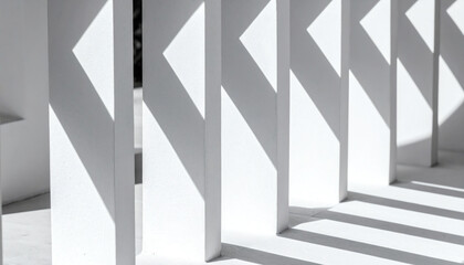 Abstract image of white pillars casting geometric shadows, creating a striking contrast of light and form