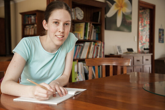Teen girl doing math work on the table at home