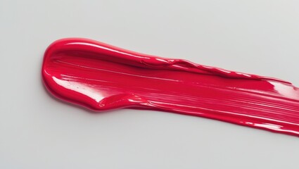 Isolated smear of liquid lipstick swatch on background. Brushstroke of lip product. Smudged texture of makeup cosmetics or paint.
