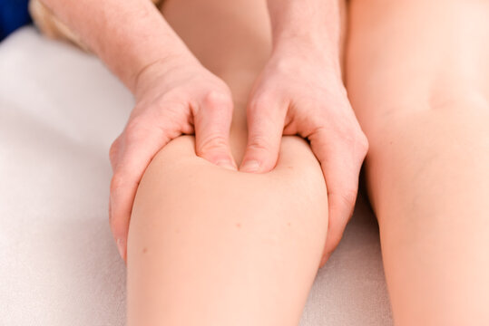 Therapist performing deep tissue leg massage