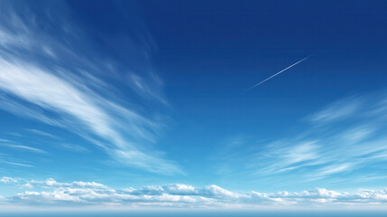 Blue sky with wispy clouds and a faint contrail stretching across the horizon creates a serene and vast atmosphere for a peaceful and airy landscape vista.