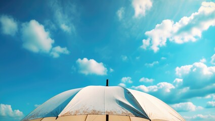An eye-catching close-up of a sizable umbrella against a lively sky with gentle clouds.