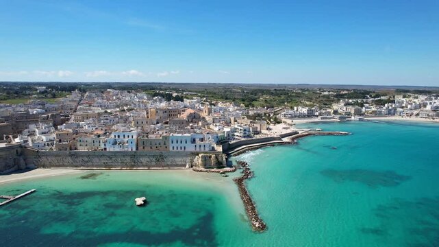 Otranto - Italy, Apulia - side aerial view over the blue-green natural harbor along the old town with a view of the fortress
