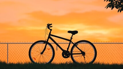 Silhouette of a Bicycle Gently Rocking Against a Fence Under an Orange Sunset Sky