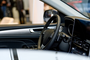 A close-up of a modern car's steering wheel with control buttons