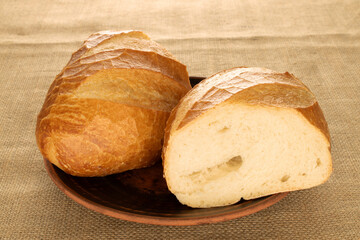 One wheat bun on a jute cloth, close-up.