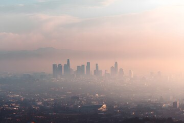Misty Morning Over Los Angeles Skyline with Soft Hues and Glow