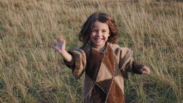Enfant souriant courant dans une prairie, sc&egrave;ne joyeuse en tenue rustique dans la nature

