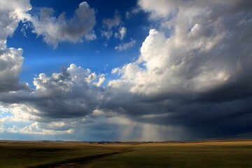 Fototapeta premium Dramatic Sky Over Open Field with Shadows and Light Play