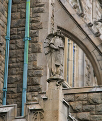 Obraz premium Gothic Revival architecture church that looks like a medieval castle with columns, carvings, arches and large stone entrances. 