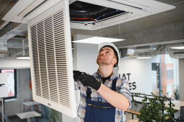 Electrician repairing ventilation system in building