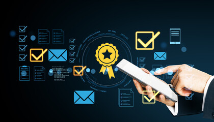Businessman using digital tablet with glowing icons of quality certification, checklist, and communication on dark background.