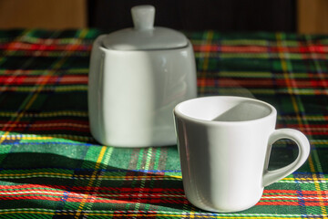 White Ceramic Mug and Sugar Bowl on Tartan Tablecloth