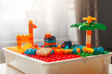 Colorful toy structures including a giraffe and palm tree built with construction blocks on a baseplate. Creative childhood play.