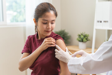 People getting a vaccination to prevent pandemic concept. Woman in medical face mask  receiving a...