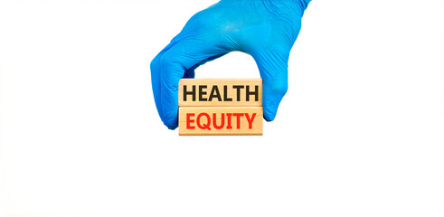 Health equity symbol. Concept words Health equity on beautiful wooden blocks. Doctor's hand in blue medical glove. Beautiful white background. Medical healthy lifestyle health equity concept.
