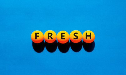 Fresh symbol. Concept word Fresh on beautiful yellow tennis ping pong balls. Beautiful wooden table...