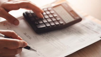 Woman hands calculating tax at desk