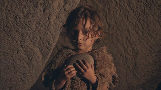 Petite fille en haillons tenant un objet dans une grotte, sc&egrave;ne dramatique et cin&eacute;matographique

