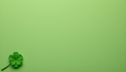 a solid green background with a single clover resting on it near the bottom left corner. there's also a subtle light blue gradient at the top right.