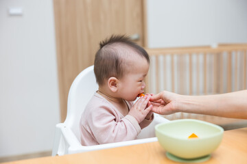 Baby trying whole carrot pieces for first time