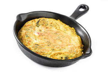 Omelette cooking in a cast iron pan on white background