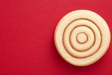 Circular cinnamon roll on red background