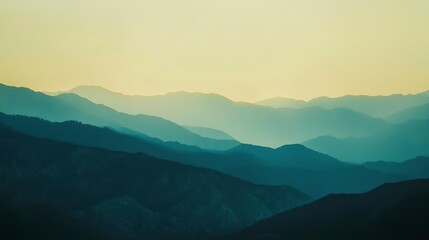 Fototapeta premium Serene landscape of layered mountains at sunset, soft light and hazy atmospheric perspective.
