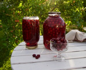 cherry compote drink on garden background in august