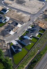Aerial photo of a new residential development area where some lots contain finished houses while others are undeveloped or under construction.